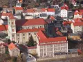 Widok z góry na miasteczko z czerwonymi dachami, w centrum imponujący kościół i zabudowania. To urokliwe bardo śląskie.
