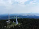 Wieża widokowa niczym wielka sowa, ile się wchodzi, góruje nad lasem. Obok maszt telekomunikacyjny.