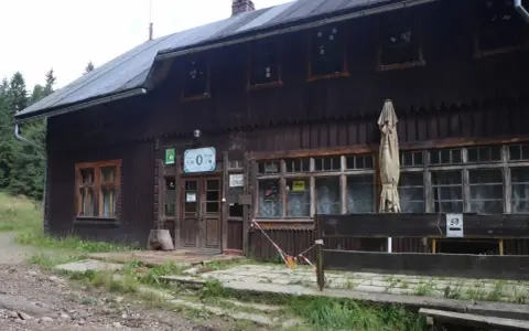 Drewniane schronisko, jakby mała sowa rzeczka, z tabliczką "ZAWIESZONO REMONT".