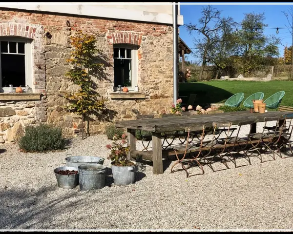 Rusty metal chairs await guests at a rustic table, perfect for enjoying the charm of agroturystyka Dolny Śląsk.