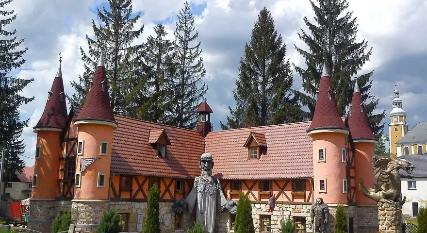 Zamek śląskich legend z wieżyczkami i kamiennymi rzeźbami.