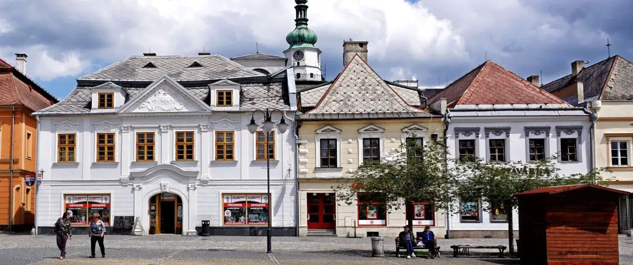Rynek w Bruntalu w Czechach. Kolorowe kamienice z charakterystycznymi dachami i wieżą zegarową.