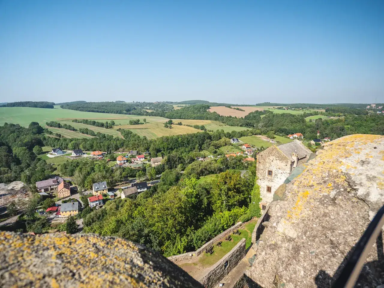 Widok z mur&oacute;w zamku Bolk&oacute;w na malowniczą dolinę z domkami i polami.
