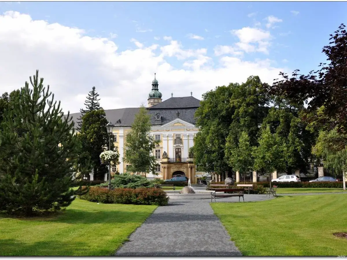 Piękny pałac w Bruntalu Czechy, otoczony zielonym parkiem z fontanną i ławkami.