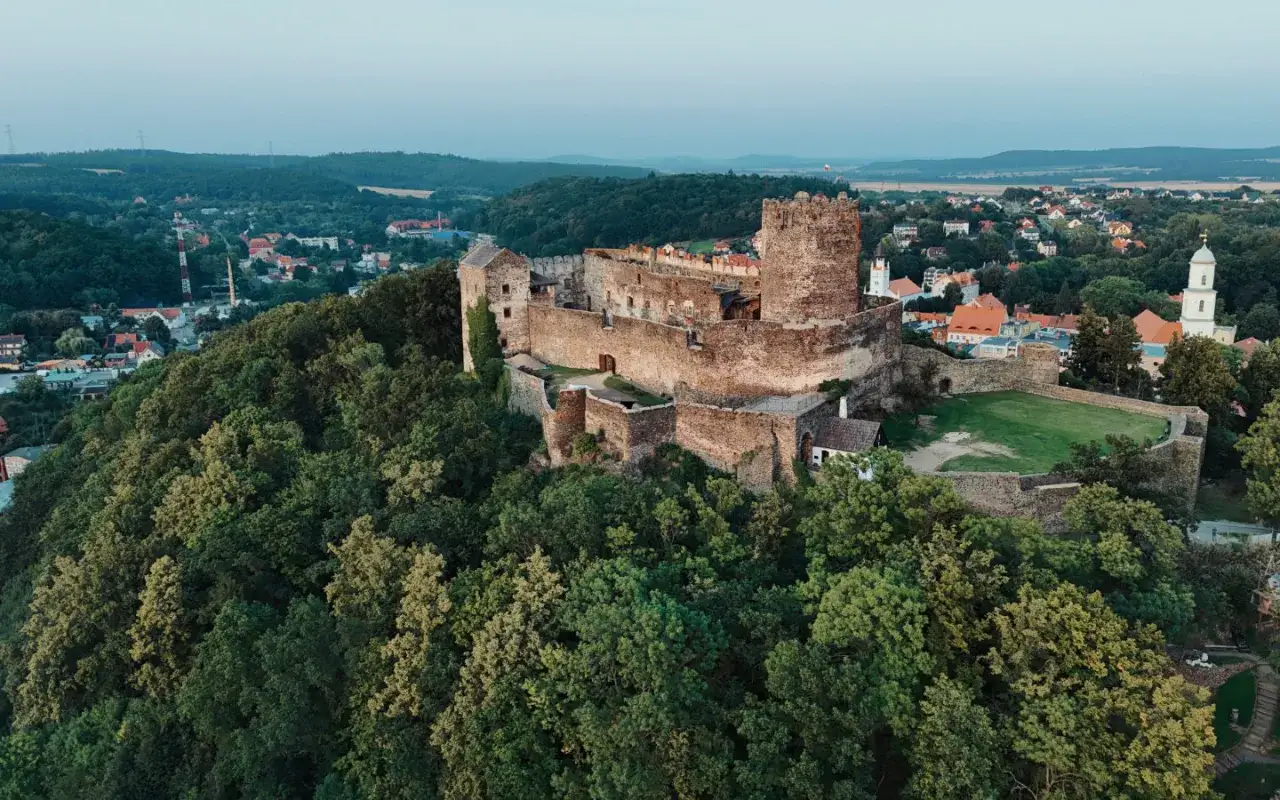 Zamek Bolk&oacute;w g&oacute;ruje nad zielonymi wzg&oacute;rzami, otoczony lasem i miasteczkiem. Jego kamienne mury i wieże świadczą o bogatej historii.
