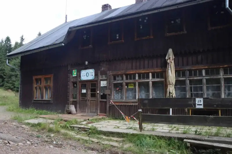 Drewniane schronisko, jakby mała sowa rzeczka, z tabliczką "ZAWIESZONO REMONT".